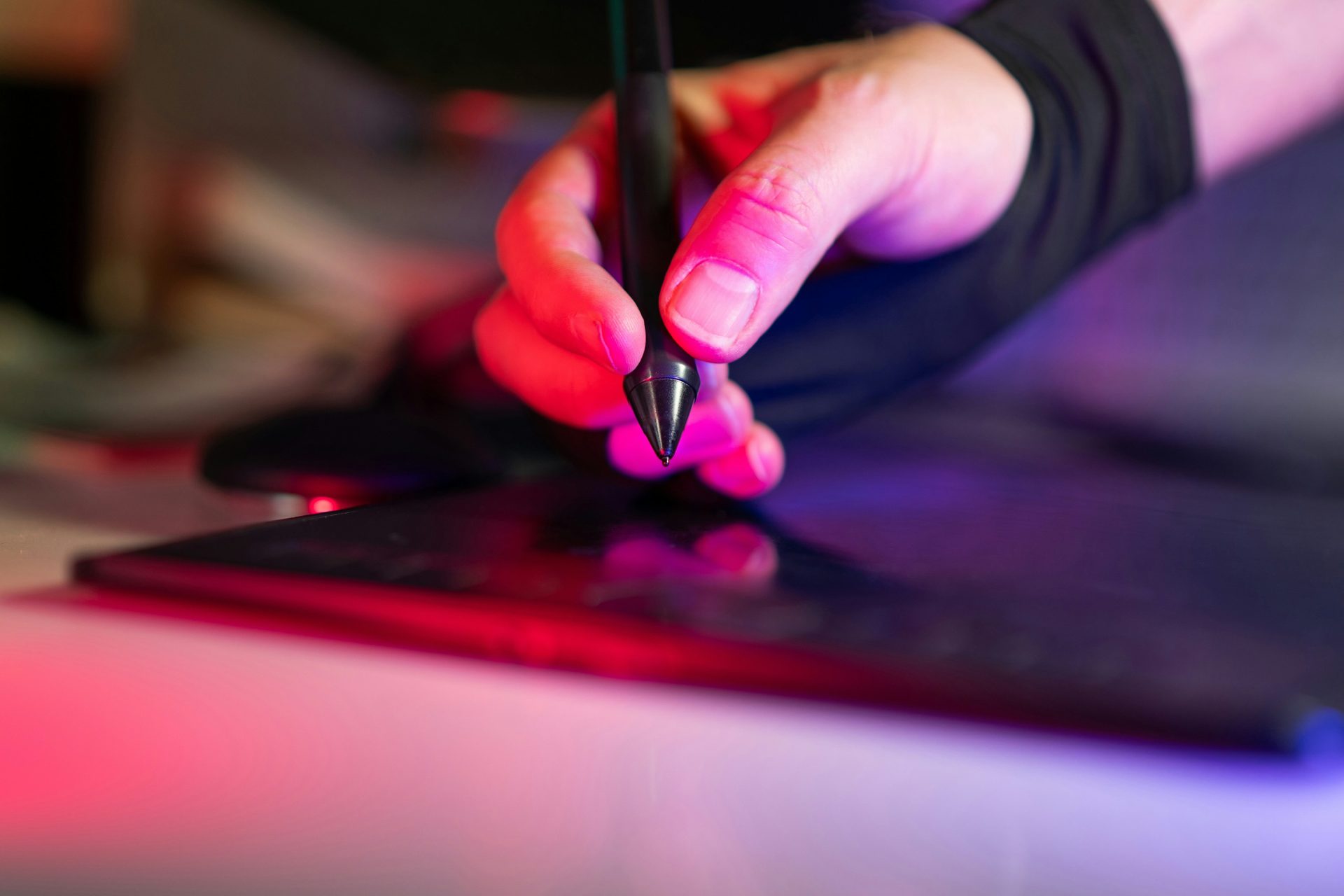 Eine Person, die mit einem Stift auf einem Laptop schreibt